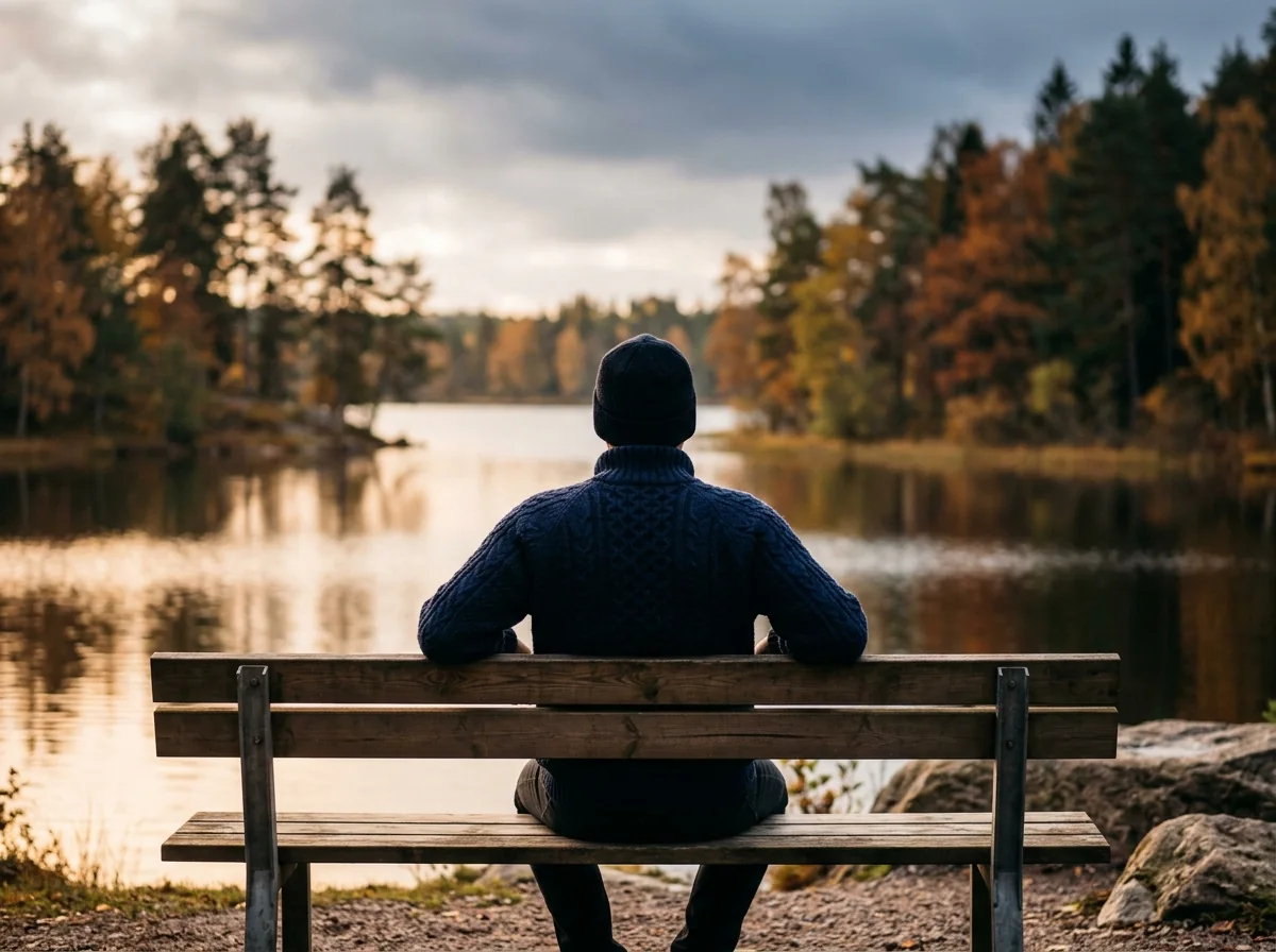 Anonym person sitter utomhus vid en sjö i Sverige i höstljus - illustrativ bild för aktiv livsstil